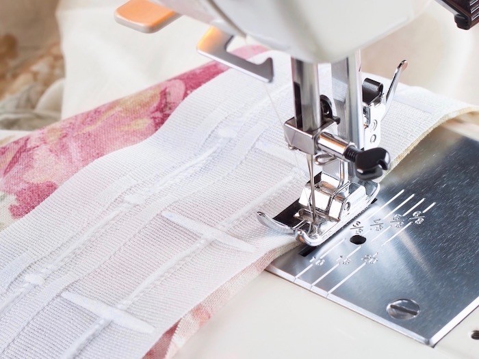 Pink and white fabric up close in sewing machine